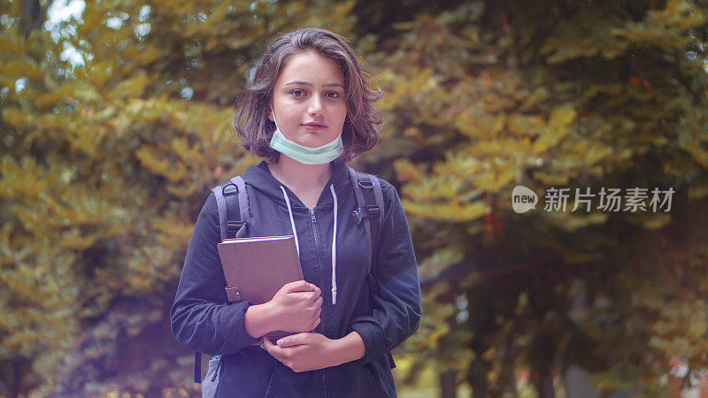 戴口罩的年轻女性，Covid-19概念。校园、学生-新常态生活理念- Live滤镜。